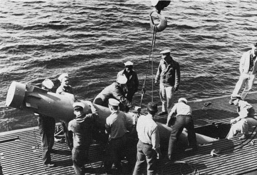 Torpedo being loaded as seen on deck of a diesel sub.