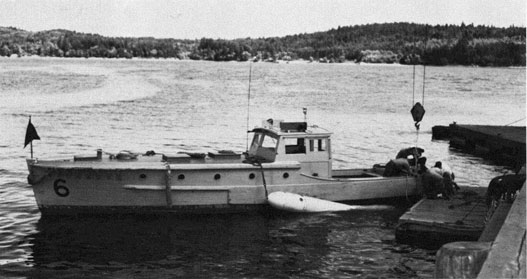 Wooden launch with torpedo alongside.