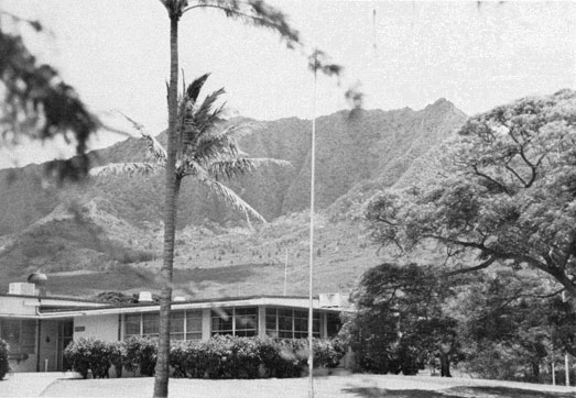 Photo of the main building of the Hawaii Detachment at Lualualei with mountains in the background.