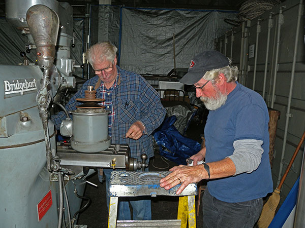 Two repairmen working on the mill