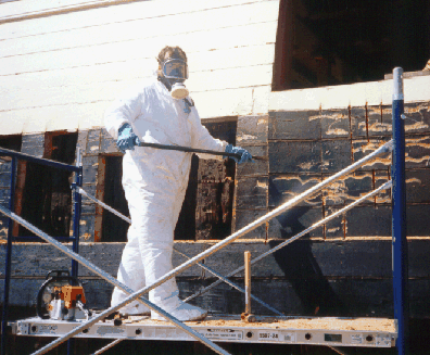 Photo of worker in full body suits & respirators.
