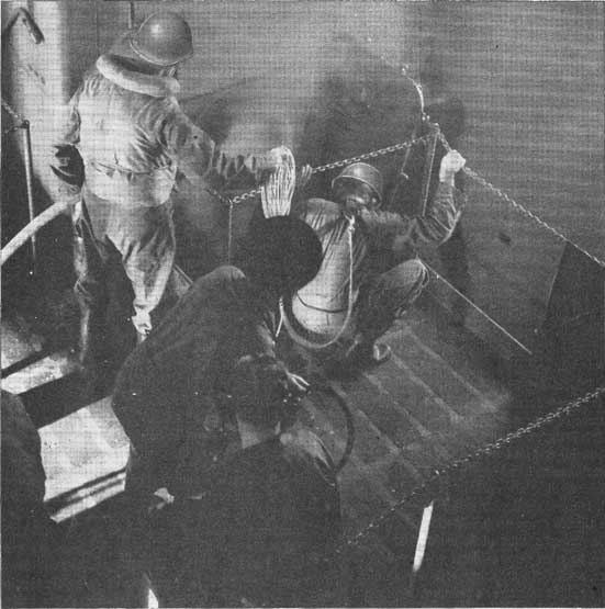 Figure 33-A. Rescue breathing apparatus being employed to investigate damage in a smoke-filled compartment.