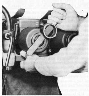 Figure 12. Tripping Cap-Retaining Catch and
Removing Breech-Casing Cap.