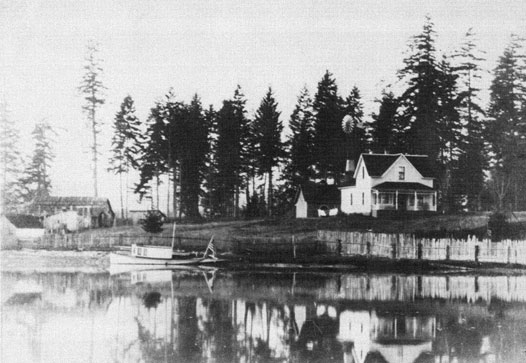 Photo taken from the water showing boat and house.