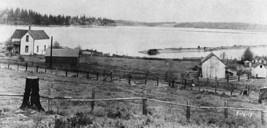 Photo of farm with water in the background.