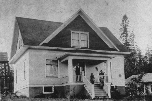 Photo of a comfortable house with the family standing on the porch.