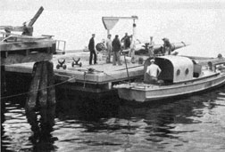 The float with torpedo is shown with a motor launch alongside.