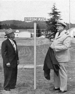 Captain William Moore standing with Louis Strom in front of a Strom Ave street sign.