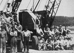 Crane operators posed in front of a crane.