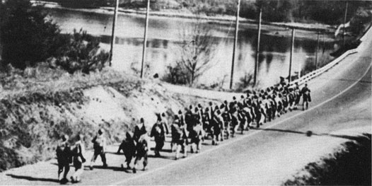 Troops marching on a road.